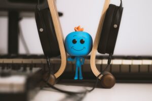 a smiling blue AI bot at a desk that highlights a humorous article about AI Bots and Creativity