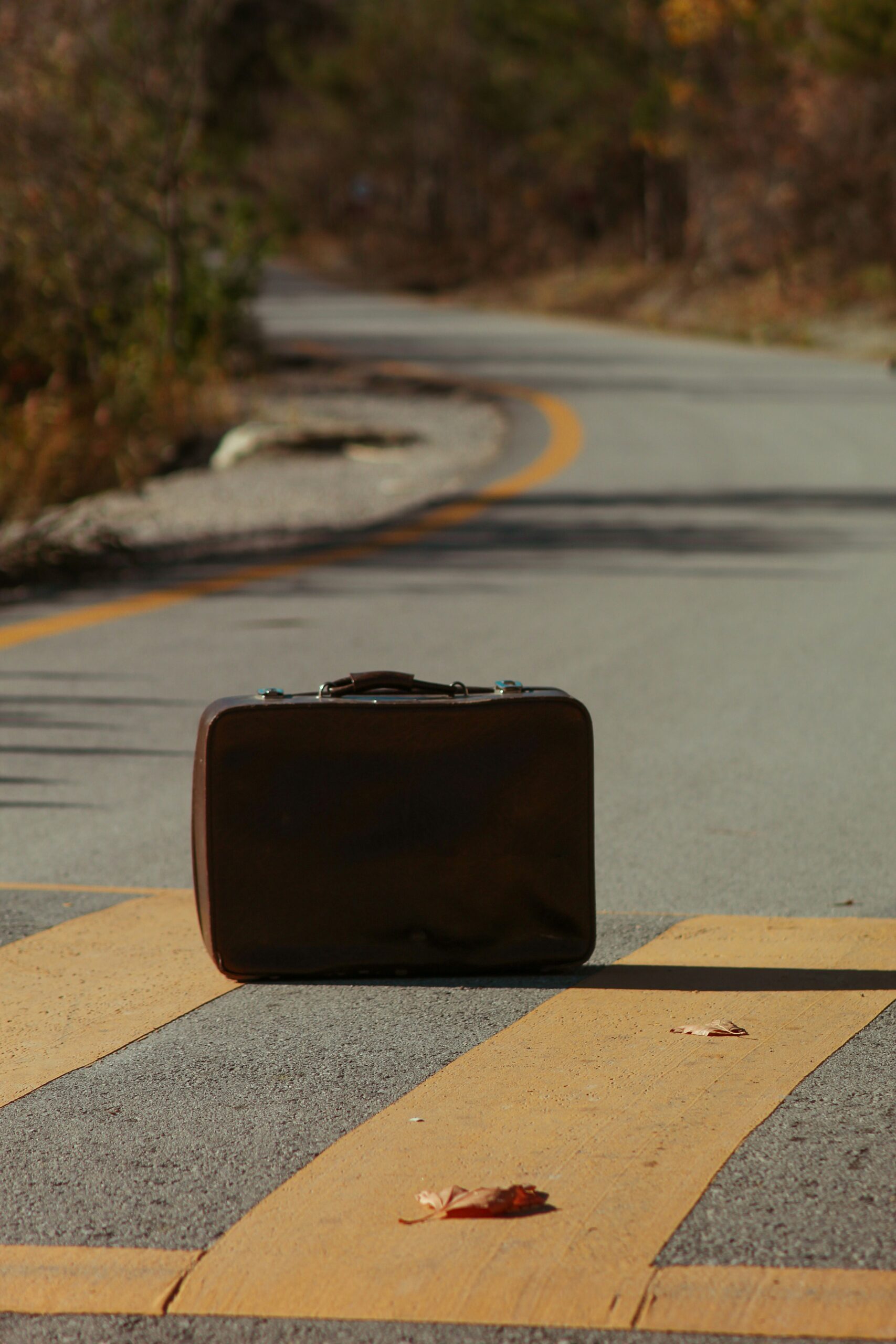 Photograph of a suitcase on a road by Esra korkmaz